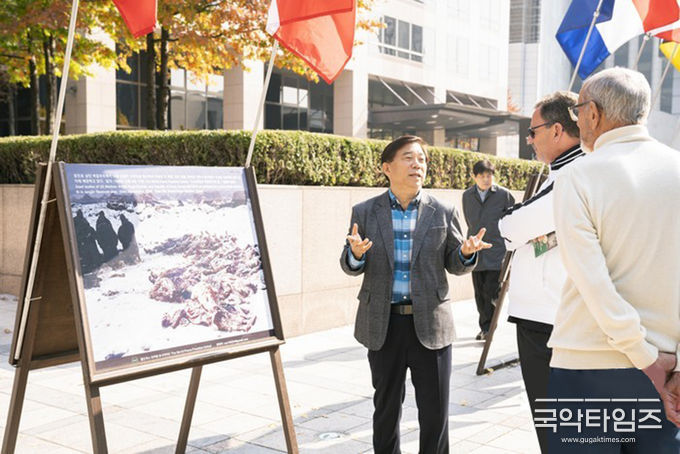 월드피스 프리덤 유나이티드 안재철 대표가 광화문을 찾은 외국인들에게 6⸱25전쟁 참상에 대해 설명하고 있다.