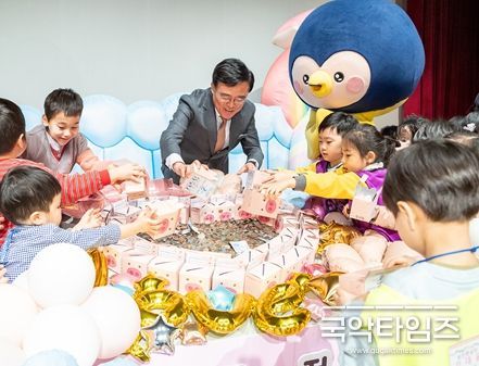 진교훈 서울 강서구청장(가운데)이 27일(목) 강서구민회관 우장홀에서 열린 ‘사랑의 저금통 마음모으기’ 전달식에서 아이들과 함께 사랑의 저금통에 든 동전을 쏟고 있다.