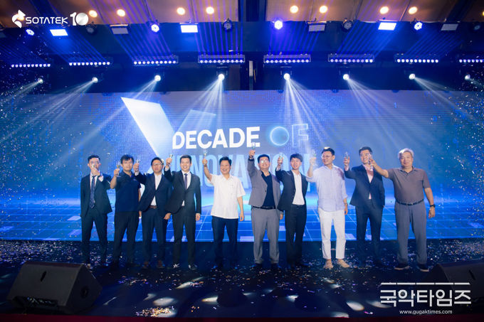 경영진과 손님들이 함께 건배하며 SotaTek의 10주년을 축하하고 있다.